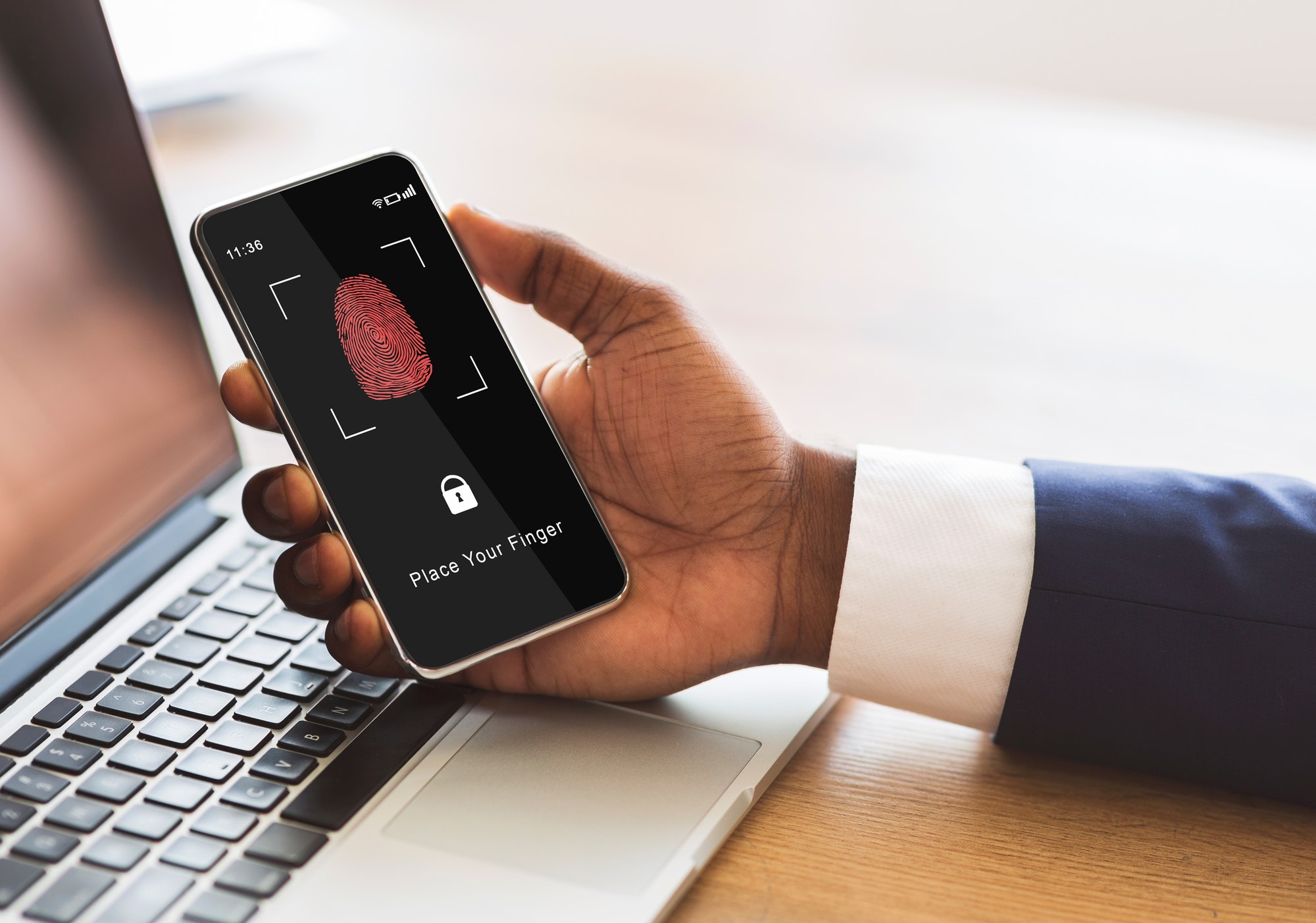 Man holding phone with fingerprint scanning smartphone app